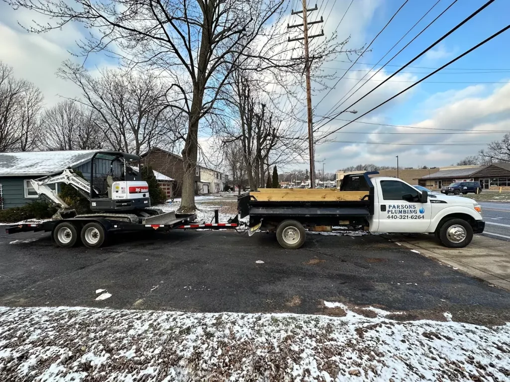 parsons vehicles parked in a snowy driveway