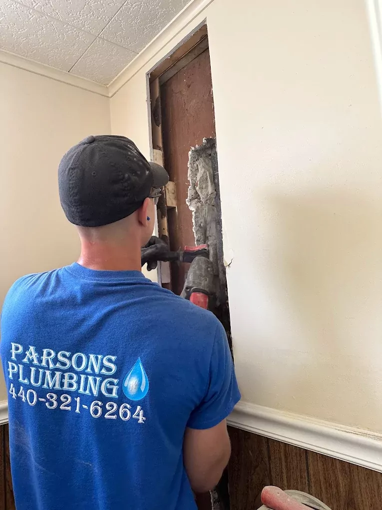 plumber working on wall pipes