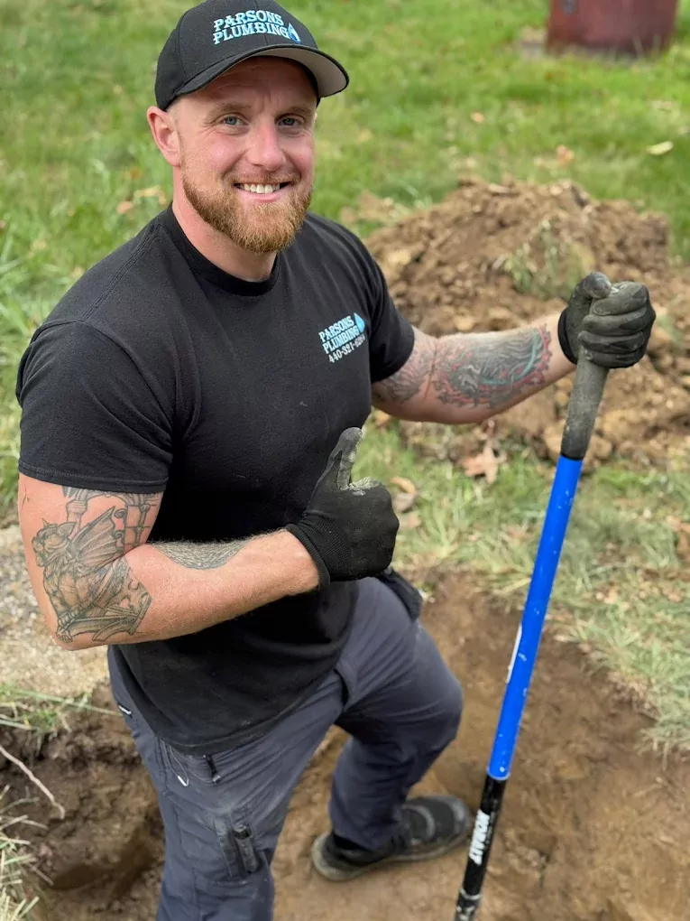 smiling plumber working on a yard
